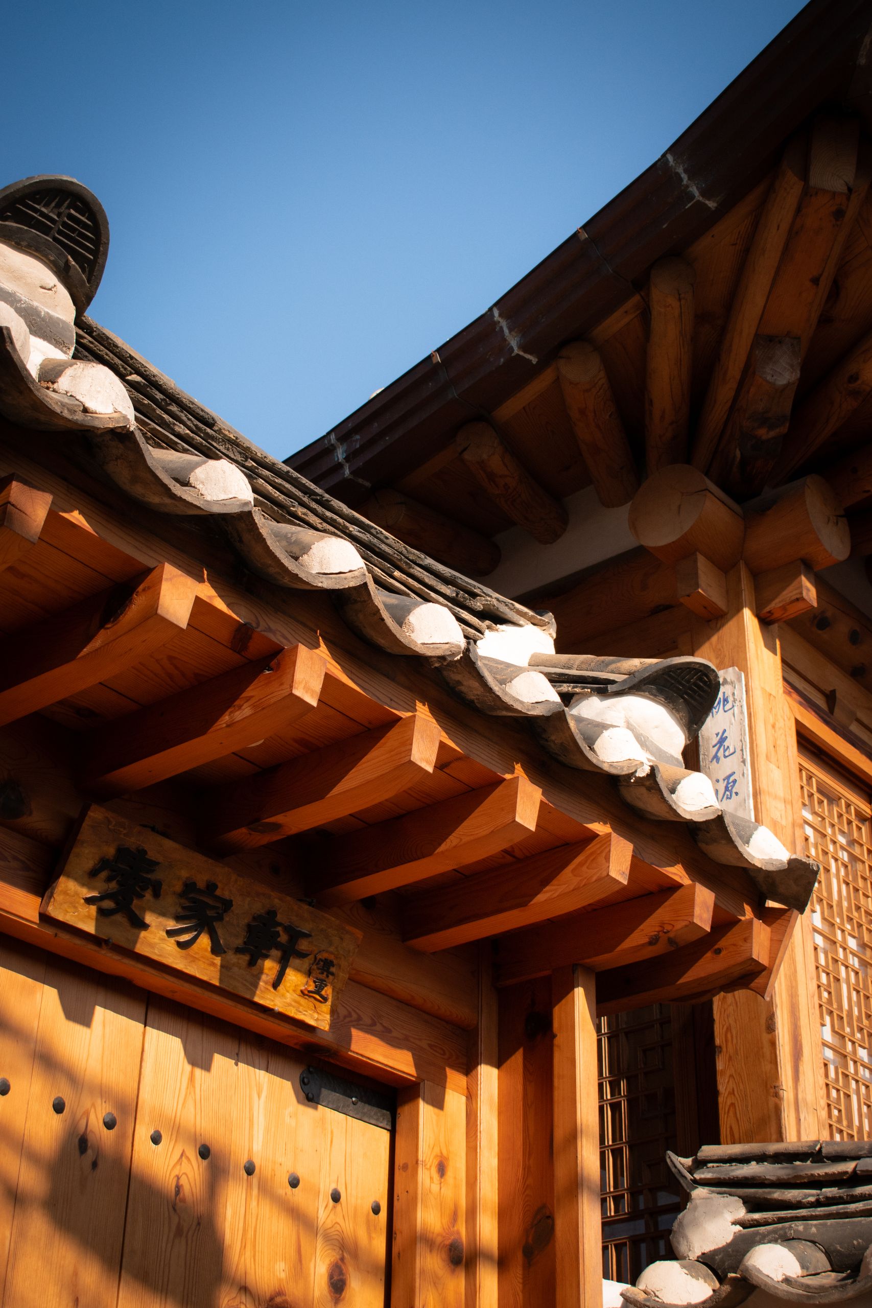 Close-up of traditional Korean architecture showcasing a wooden roof detail in Seoul, South Korea.